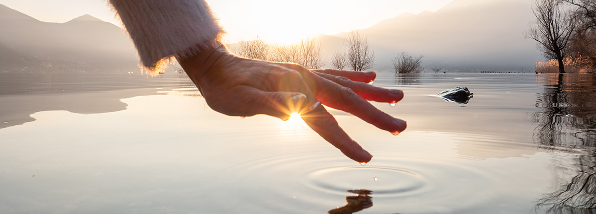 hånd rører vand i en sø